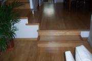 Parquet flotante en madera de Roble Natural con un acabado satinado. Observamos también escaleras forradas con mismo material.